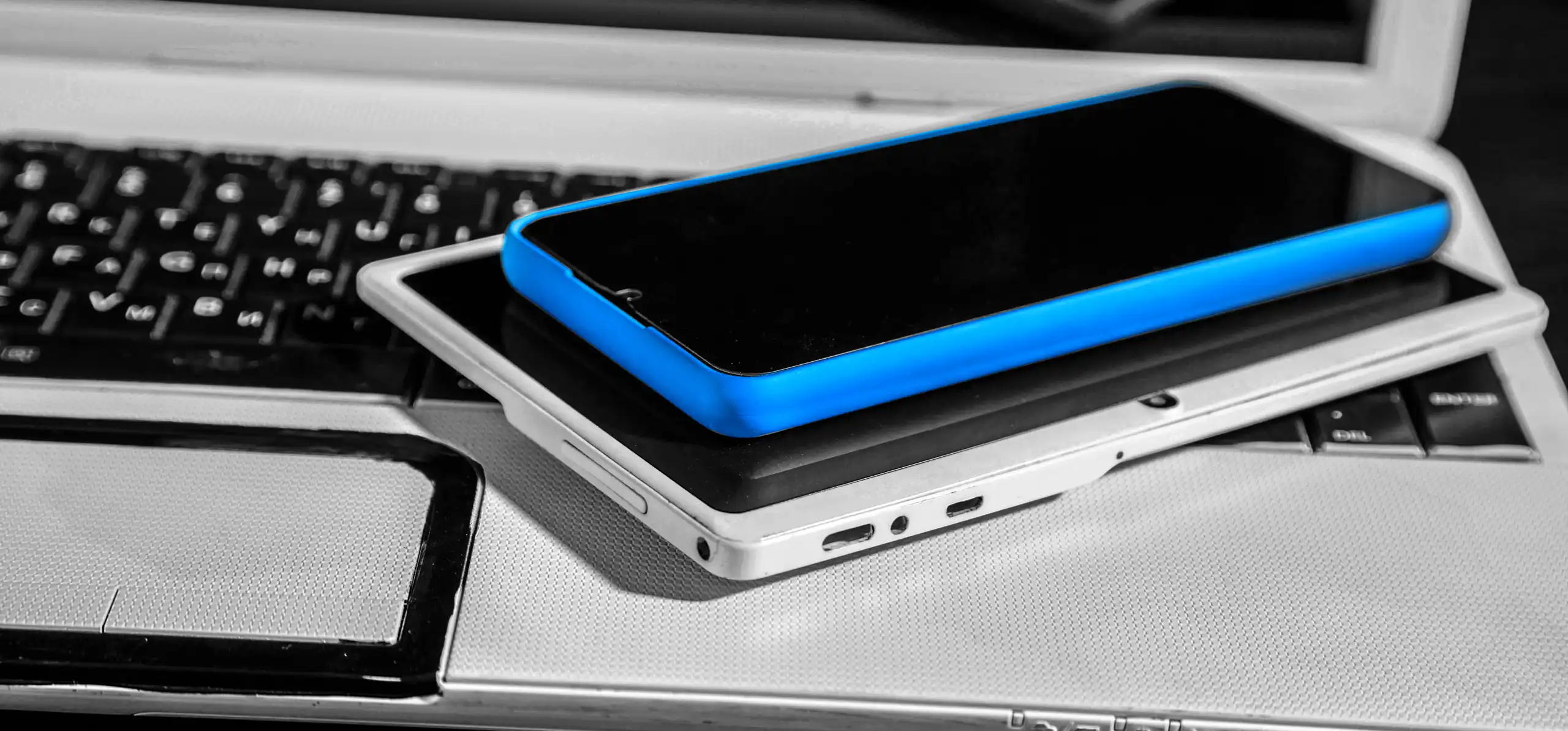 Telefon i tablet położone na laptopie, ilustrujące responsywność stron internetowych w 2023 roku